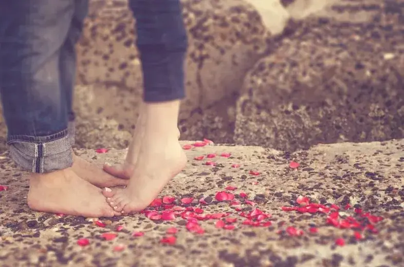 Bare feet standing on flower petals outdoors