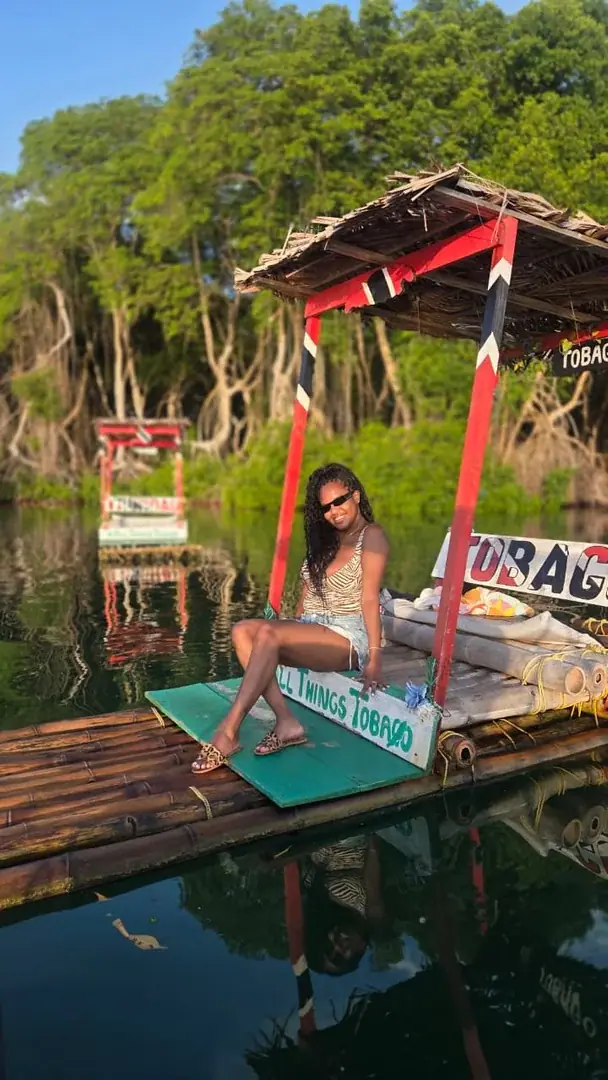Leslieann seated on a bamboo raft beside the mangroves in Tobago