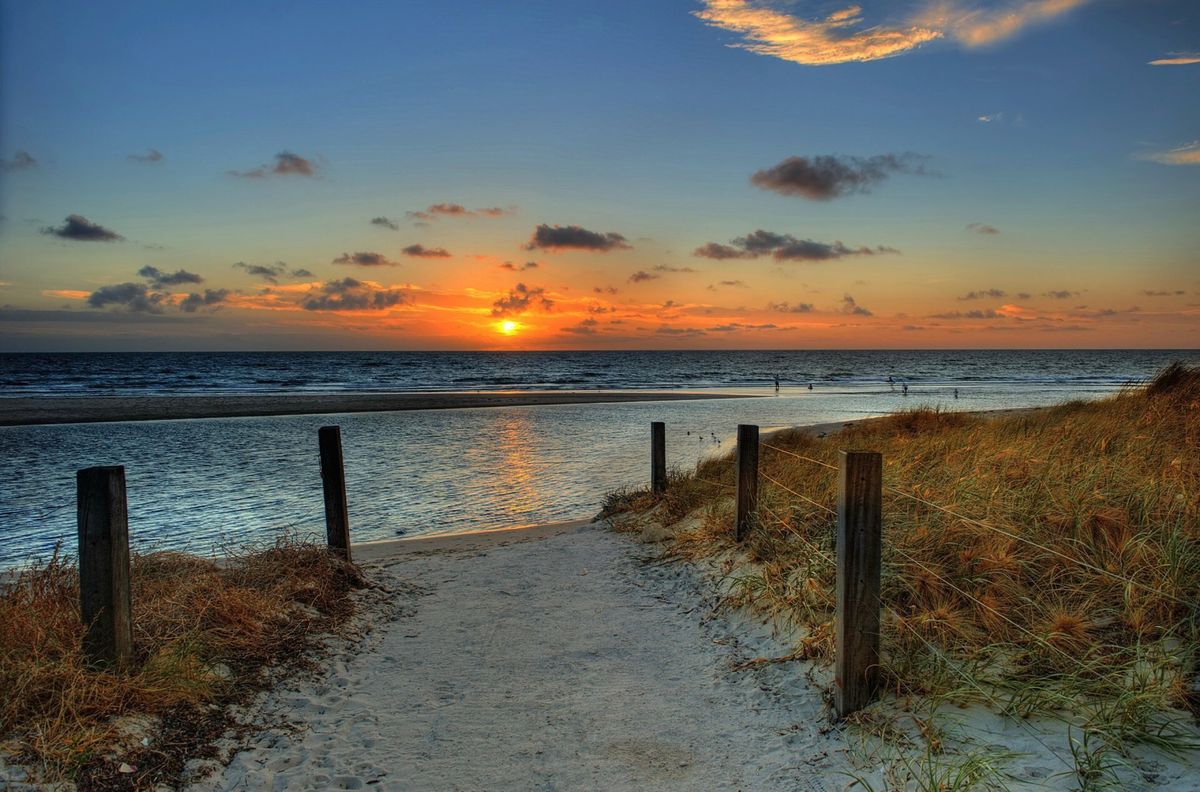 Sunset over a quiet beach and wooden boardwalk