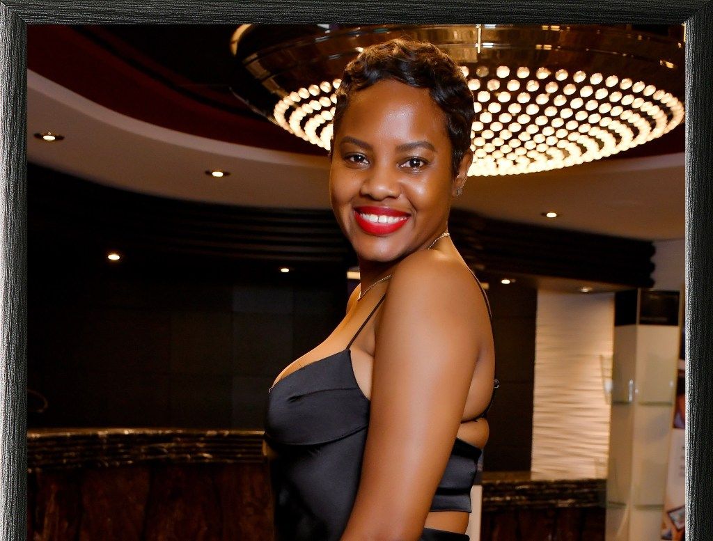 Smiling woman in a black dress at an indoor event