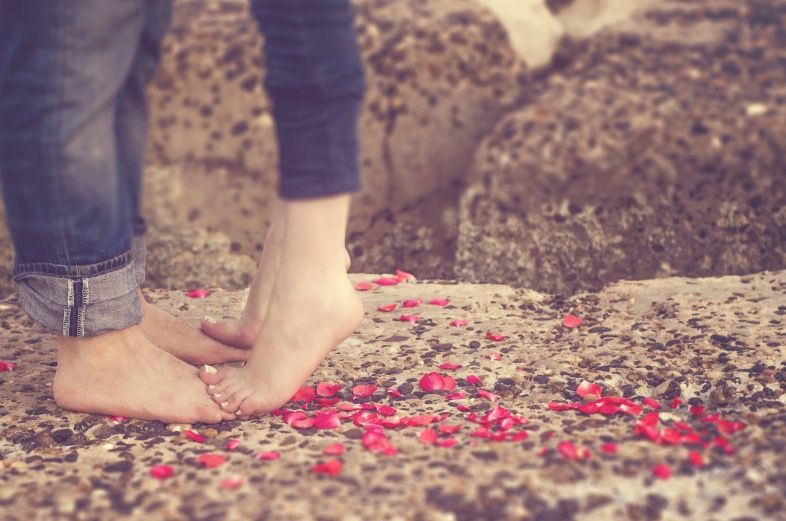 Bare feet standing on flower petals outdoors