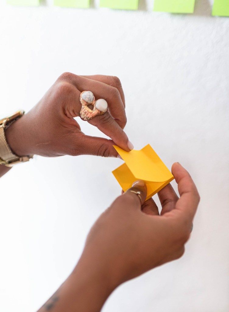 Hands opening a small yellow box