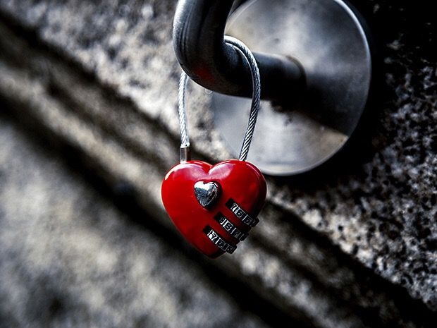 Red heart-shaped padlock attached to a metal fixture